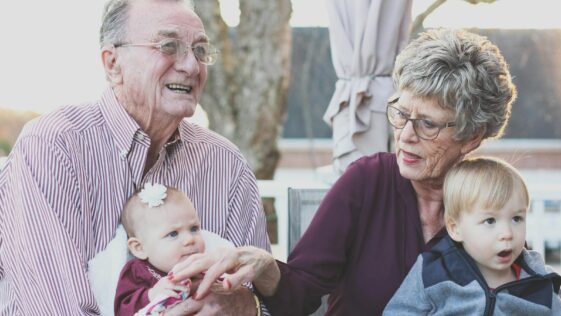 Grandmother and Grandfather Holding Child on Their Lap