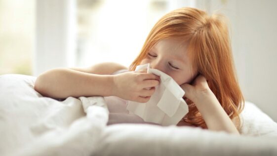 A Sick Girl Wiping Her Nose with Tissue