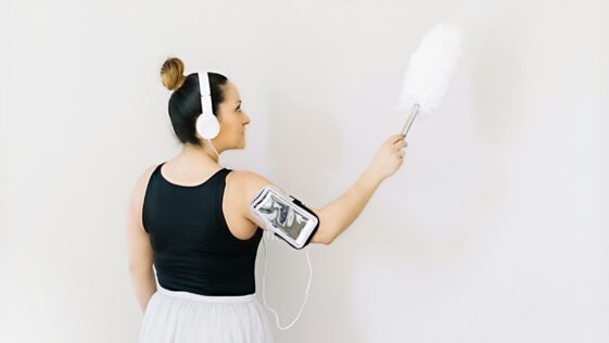 woman in black tank top and white skirt holding gray and black headphones