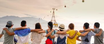 people holding shoulders sitting on wall