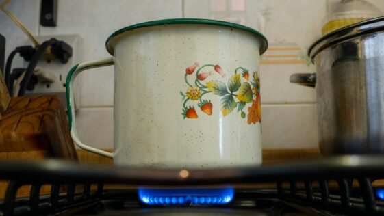 white and pink floral cooking pot on stove