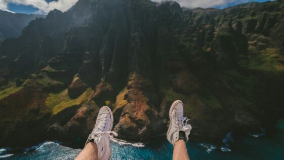 person above mountain and body of water