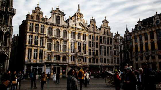 a group of people walking in front of Grand Place