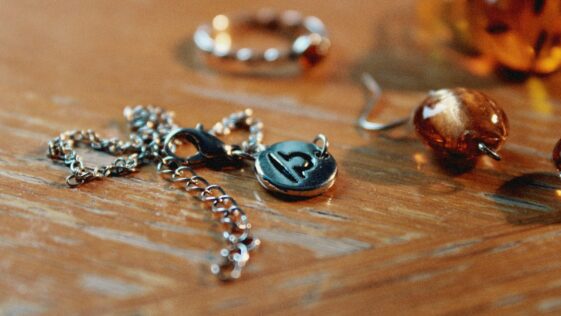 a wooden table topped with lots of different types of jewelry