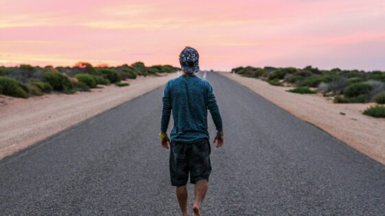 man walking on gray concrete road