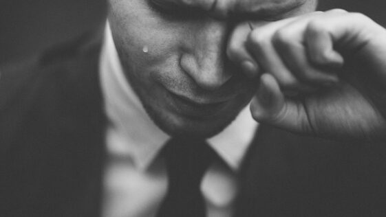 man wiping his tears