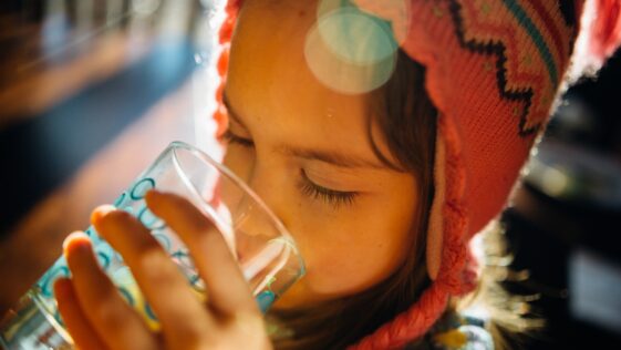 selective focus photography of girl drinking water