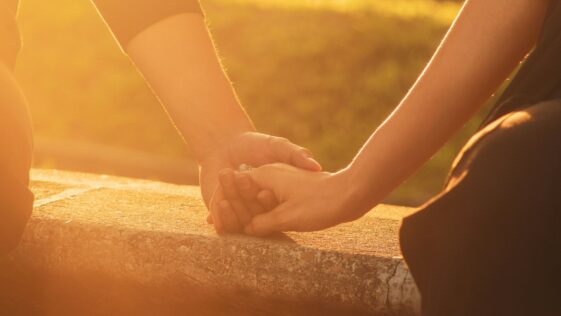 a close up of two people holding hands