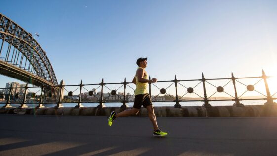man in yellow tank top running near shore