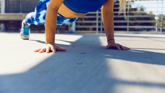 woman planking on gray asphalt road