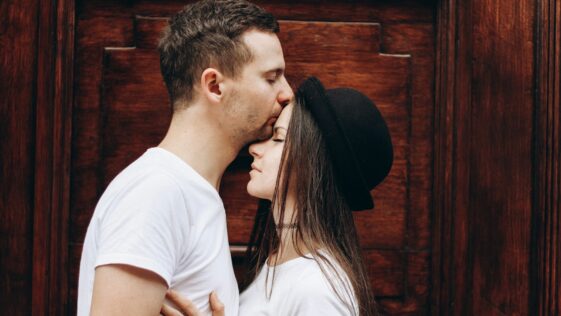 man kissing woman forehead