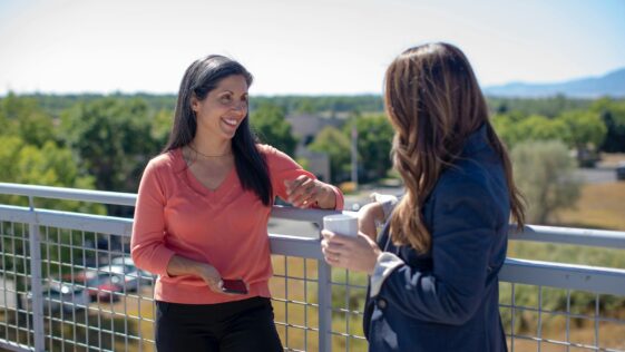 2 women standing beside railings during daytime