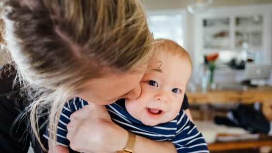 woman carrying baby in striped shirt