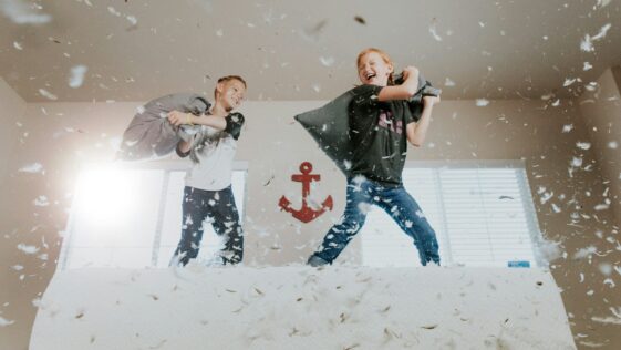 two toddler pillow fighting