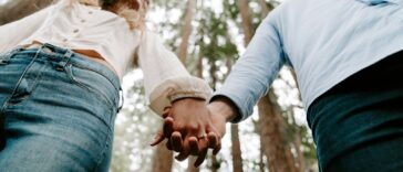 shalow focus photo of man and woman holding each others hands