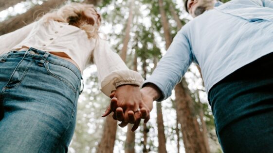 shalow focus photo of man and woman holding each others hands