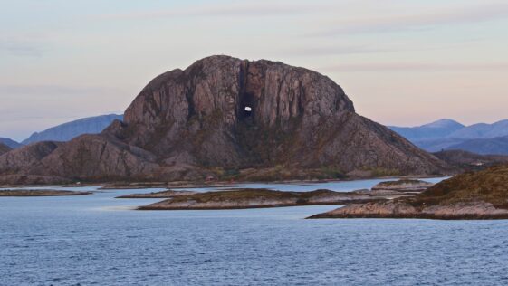 brown rock formation on sea water under white sky during daytime