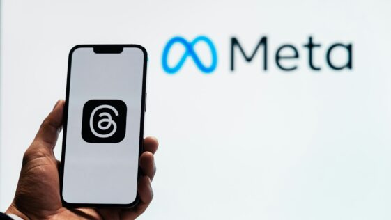 a person holding up a cell phone in front of a sign