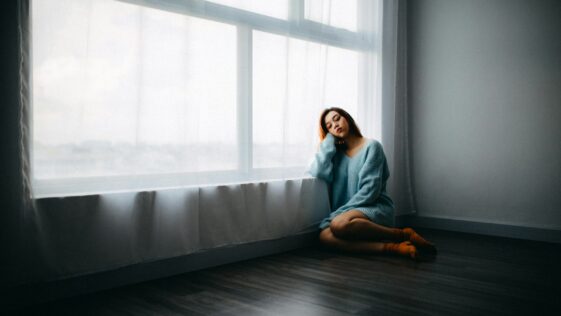 woman sitting on floor near window