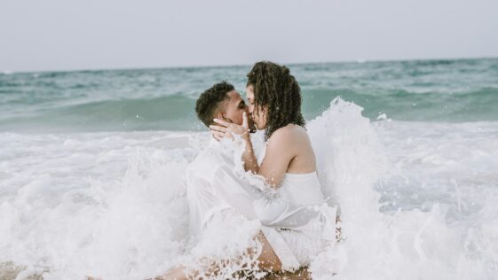couple kissing on beach during daytime