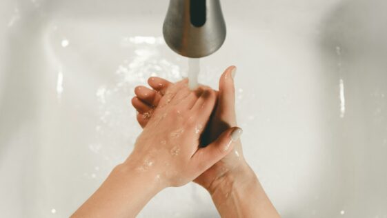persons feet on white bathtub