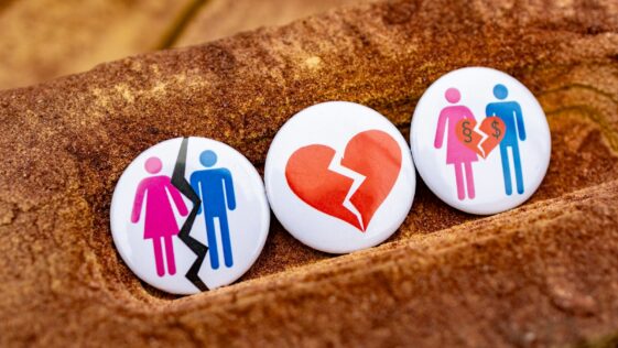 Three buttons with people and a broken heart on them