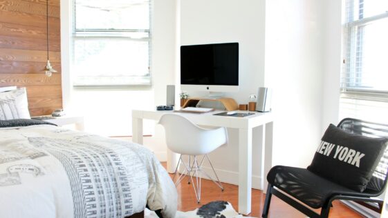 white wooden desk near bed inside the room