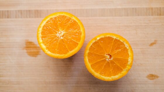 sliced orange fruit on brown wooden table