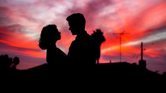 silhouette of man and woman facing each other during golden hour