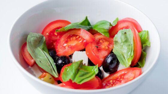 red and green bell pepper on white ceramic bowl