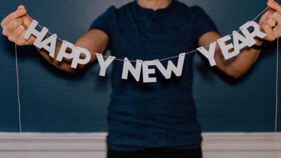person holding happy new year decor