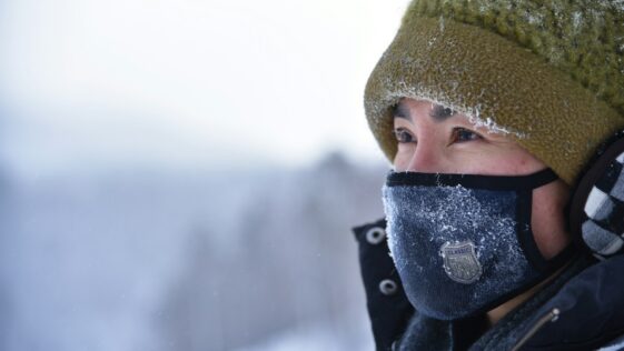 woman wearing green knit cap and blue mask