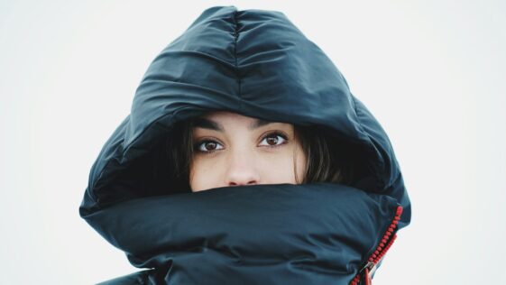a woman in a black jacket with a hood on