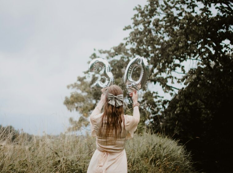 woman in pink dress holding heart shaped mirror