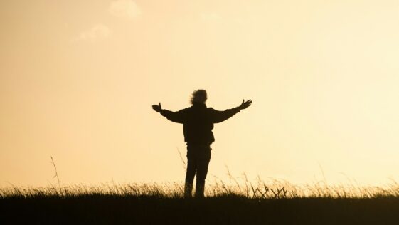 silhouette of person spreading hands