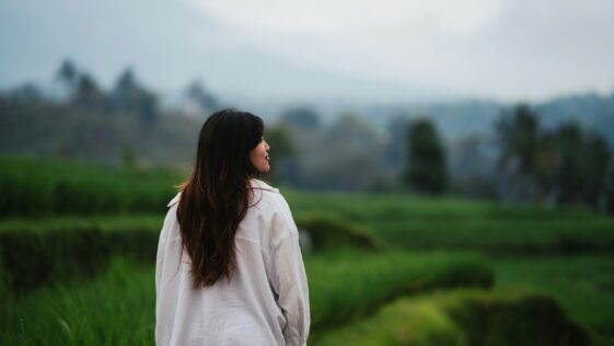 a woman standing in a field of tall grass