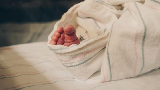 a close up of a person's hand under a blanket