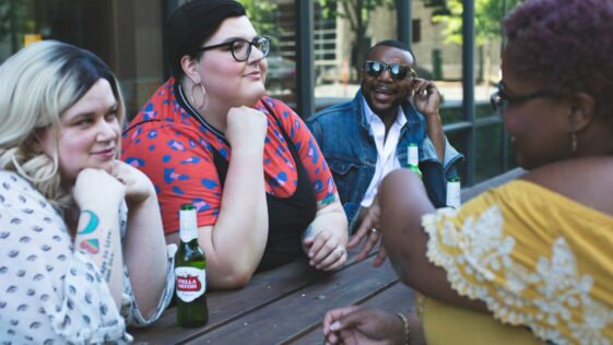 four people leaning on table