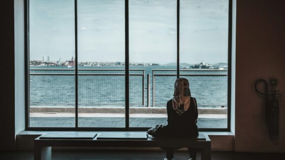 person sitting on bench watching sea