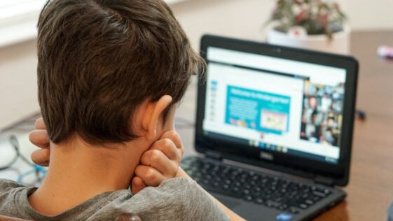 boy in gray shirt using black laptop computer