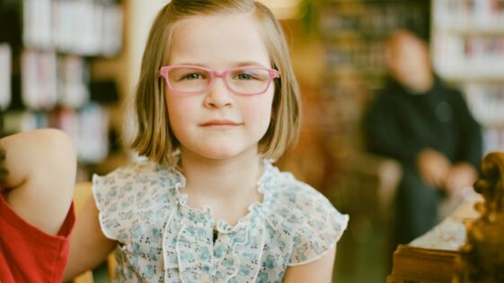 selective focus of girl sitting at table
