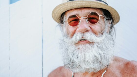 a man with a white beard and mustache wearing a hat