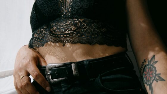 woman in black and gray lace brassiere and black denim jeans