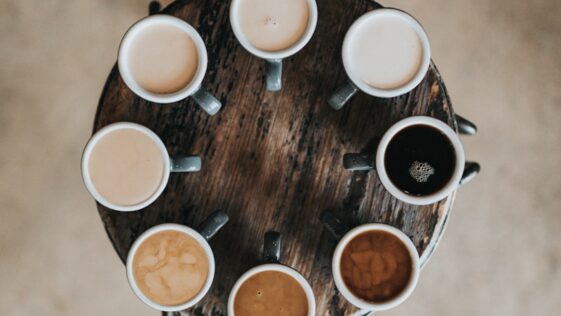flat lay photography of eight coffee latte in mugs on round table