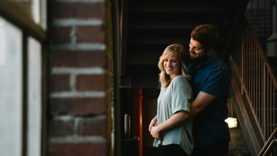 man hugging woman from behind near stair