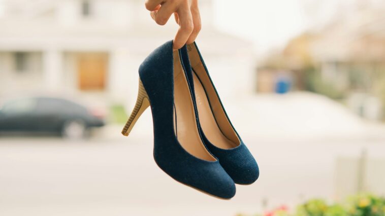 person holding black stilettos