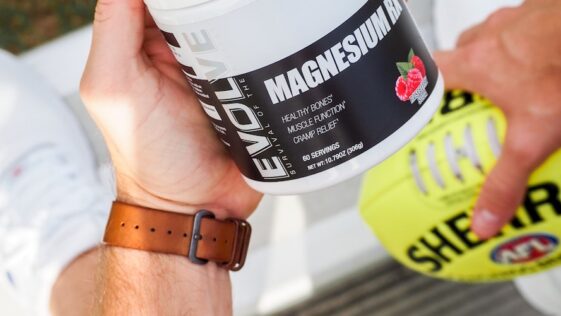a man holding a jar of vitamin supplement
