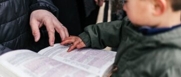 boy touching page of book
