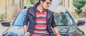 man in black leather jacket sitting on black car