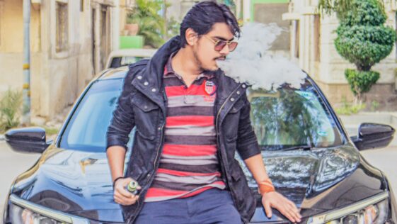 man in black leather jacket sitting on black car